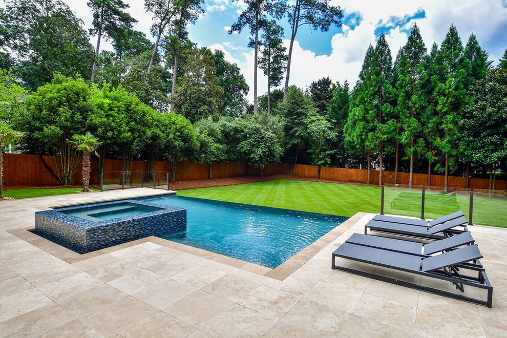 Example of a mid-sized minimalist backyard stone and rectangular infinity hot tub design in Atlanta