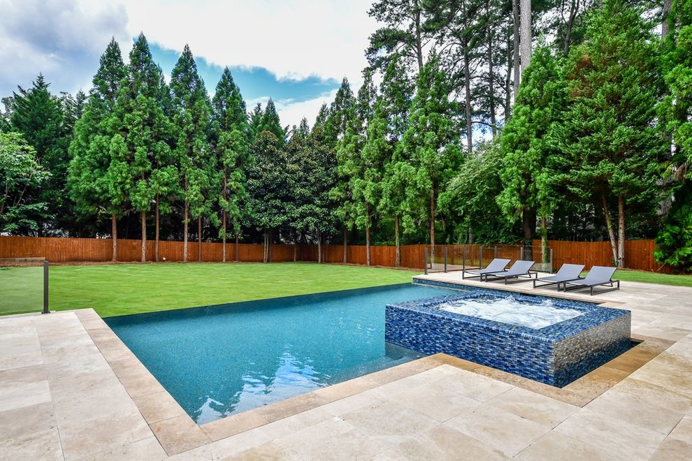 Inspiration for a mid-sized modern backyard stone and rectangular infinity hot tub remodel in Atlanta