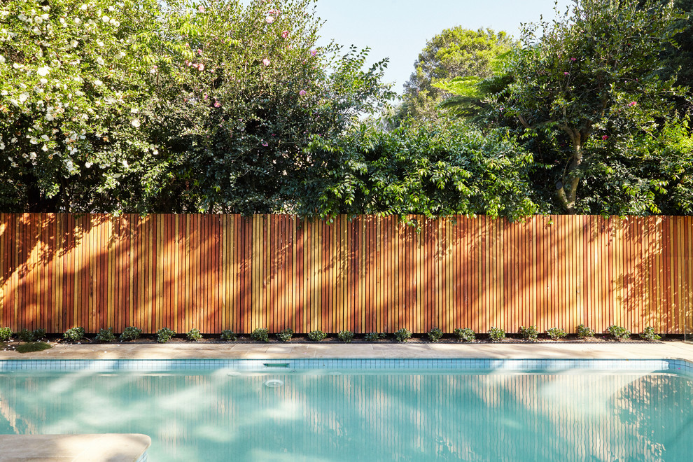 На фото: бассейн среднего размера, произвольной формы на заднем дворе в современном стиле с покрытием из плитки с