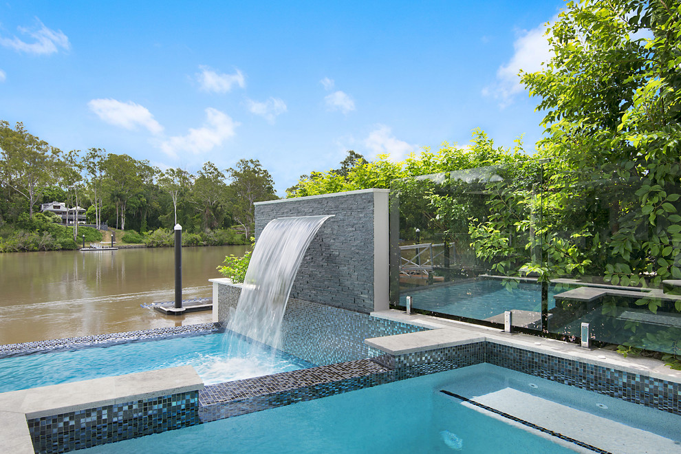 Стильный дизайн: бассейн произвольной формы на заднем дворе в современном стиле с настилом - последний тренд