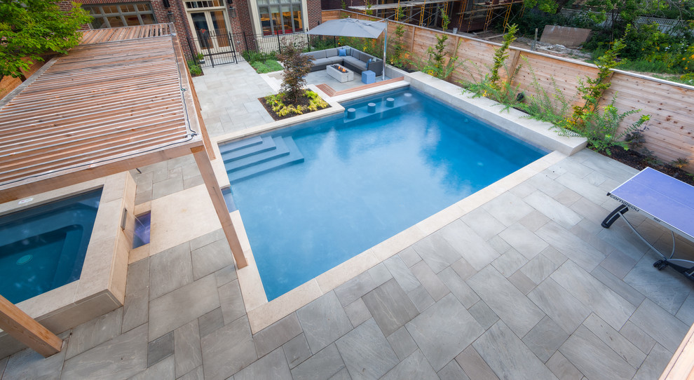 Imagen de casa de la piscina y piscina contemporánea grande rectangular en patio trasero con adoquines de piedra natural