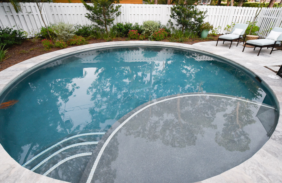 Aménagement d'une piscine arrière craftsman ronde avec des pavés en pierre naturelle.