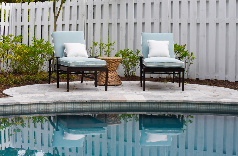Diseño de piscina de estilo americano redondeada en patio trasero con adoquines de piedra natural