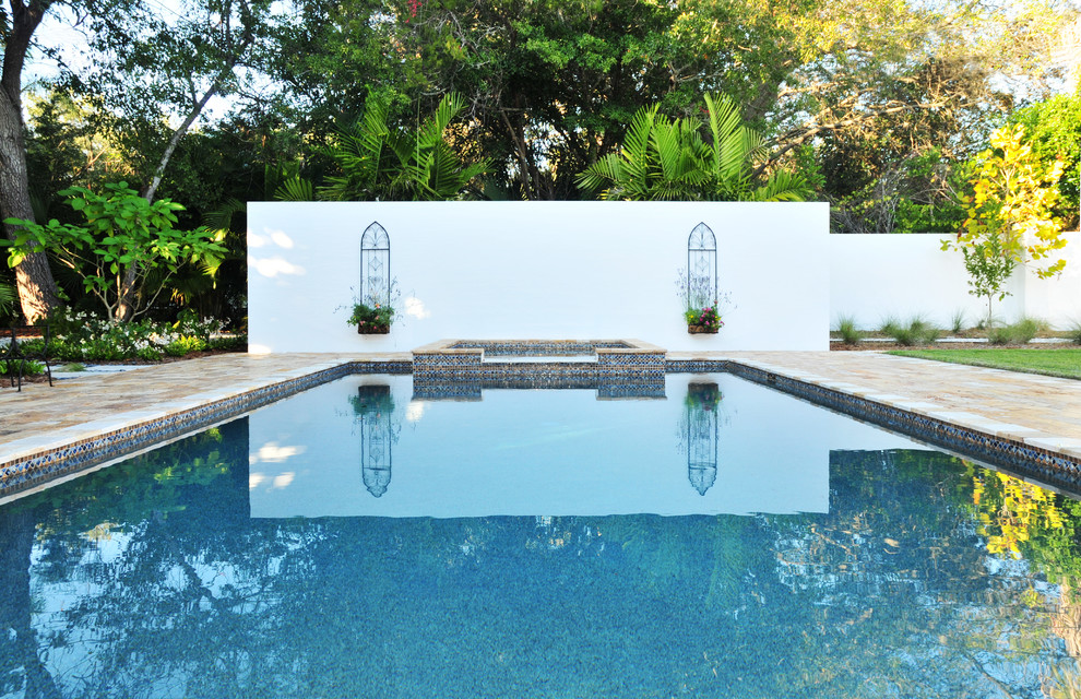 Imagen de piscina clásica renovada grande rectangular en patio con adoquines de piedra natural