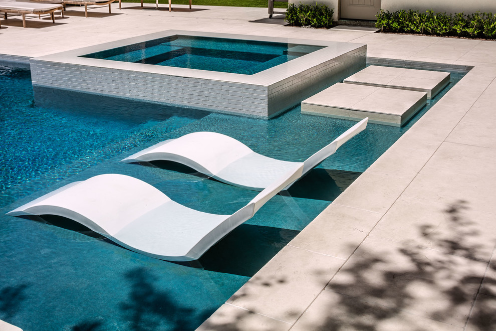 Стильный дизайн: маленький прямоугольный бассейн-инфинити на заднем дворе в современном стиле с джакузи и покрытием из плитки для на участке и в саду - последний тренд