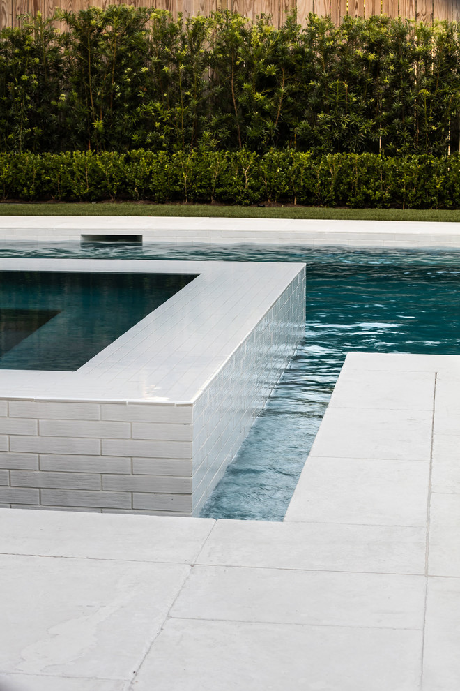 Diseño de piscinas y jacuzzis infinitos minimalistas pequeños rectangulares en patio trasero con adoquines de hormigón