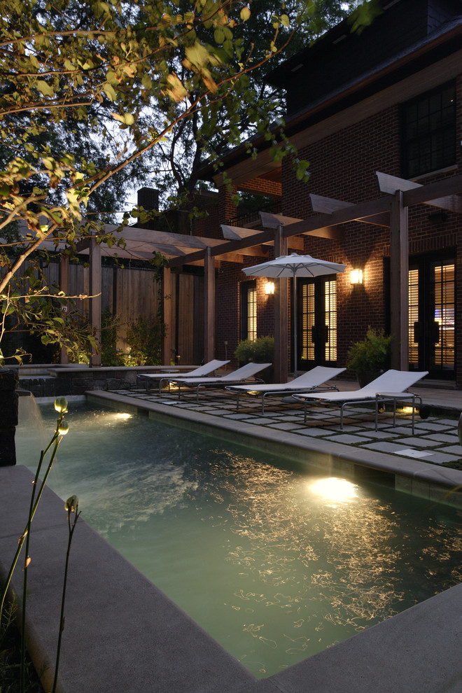 Immagine di una piccola piscina monocorsia minimalista rettangolare con pavimentazioni in pietra naturale e una vasca idromassaggio