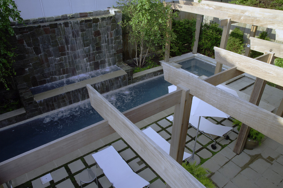 Cette photo montre un petit couloir de nage moderne rectangle avec une cour, des pavés en pierre naturelle et un bain bouillonnant.