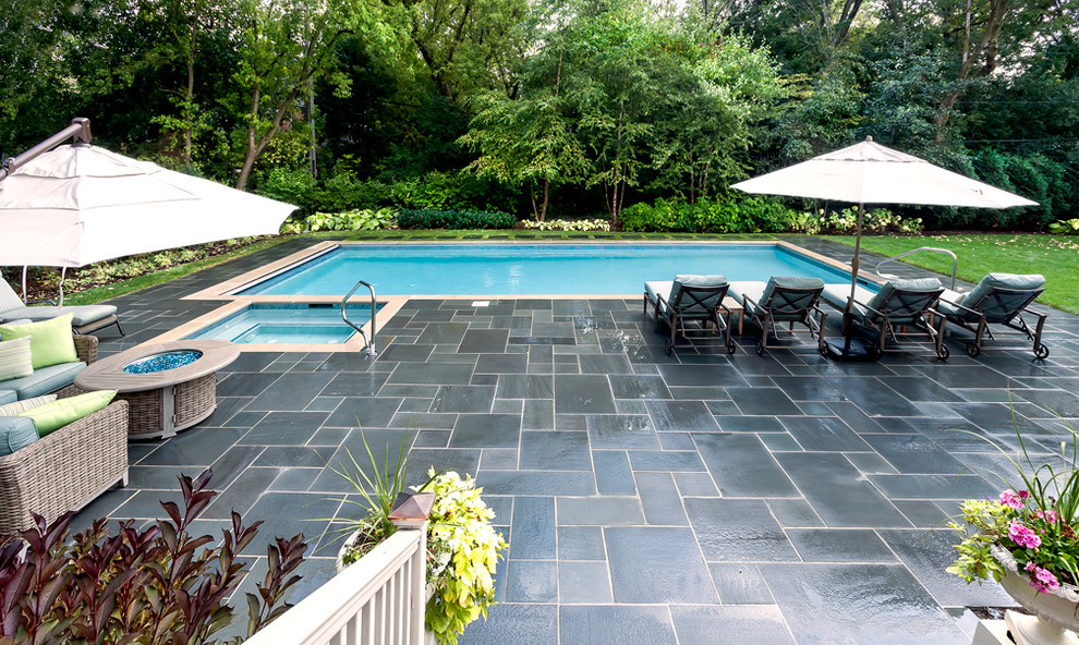 Idee per una piscina chic rettangolare di medie dimensioni e dietro casa con pavimentazioni in pietra naturale