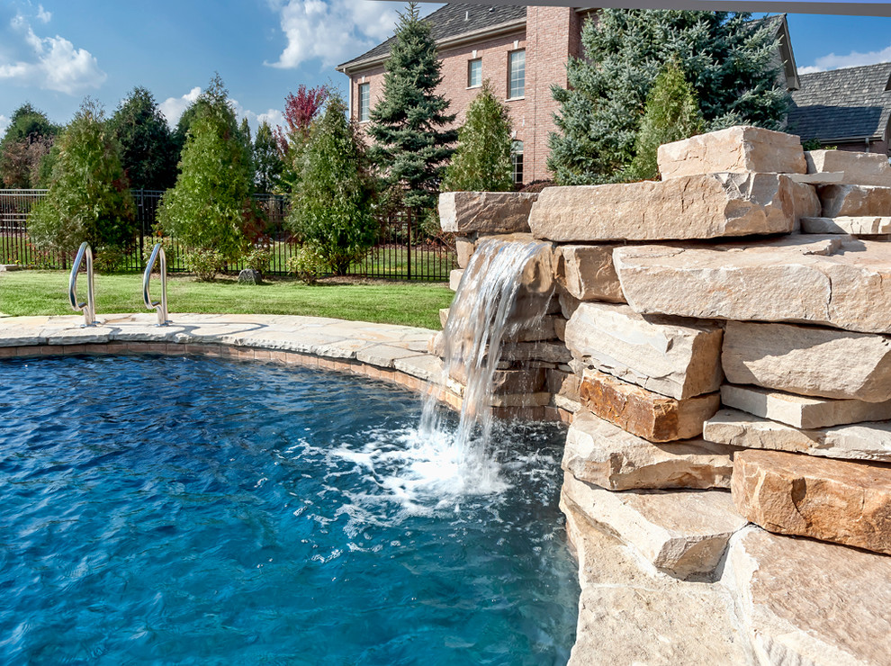 Photo of a medium sized classic back custom shaped swimming pool in Chicago with natural stone paving.