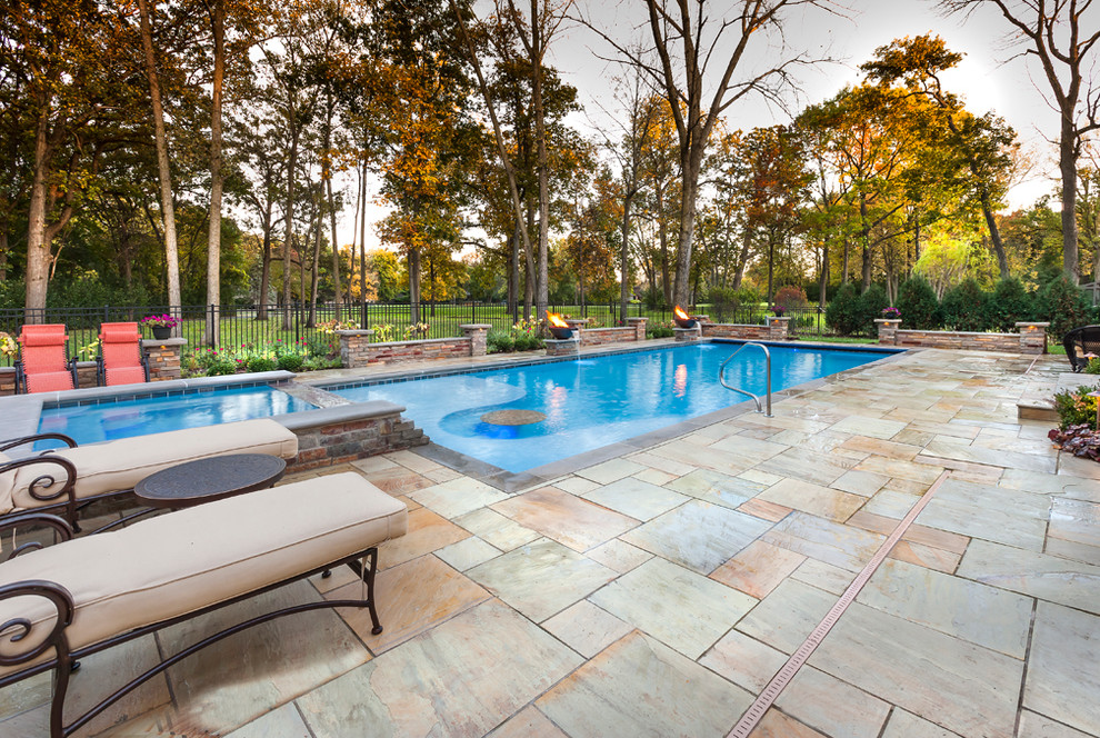 Foto de piscina clásica grande rectangular en patio trasero con adoquines de piedra natural