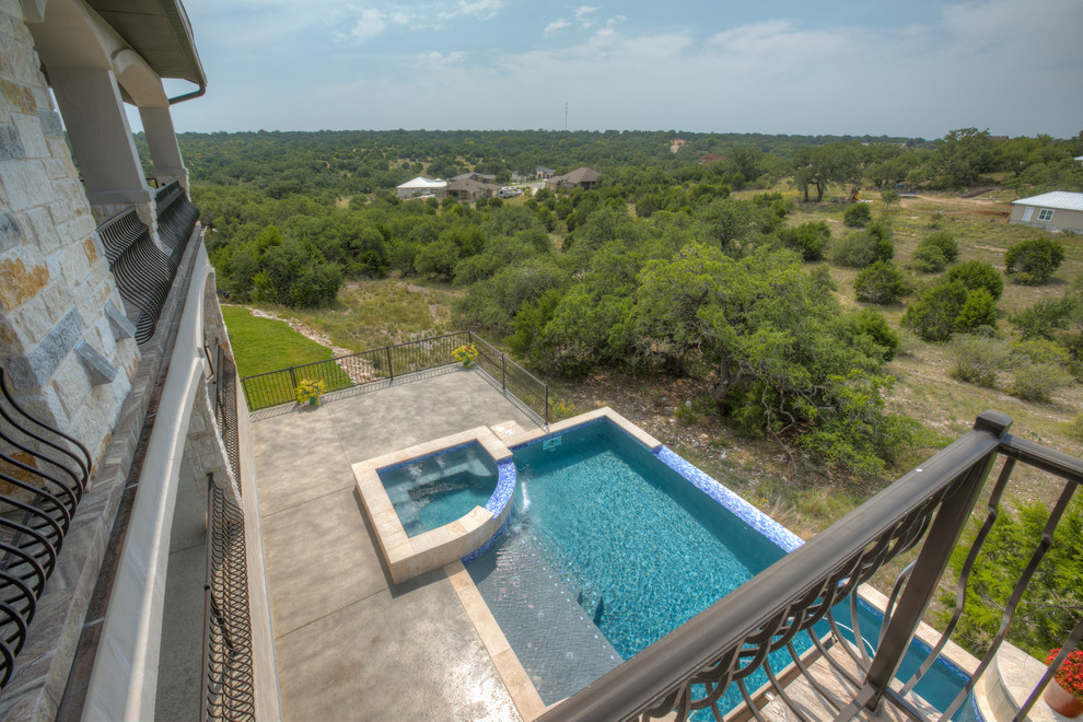 Großer Mediterraner Pool hinter dem Haus in rechteckiger Form mit Betonplatten in Austin