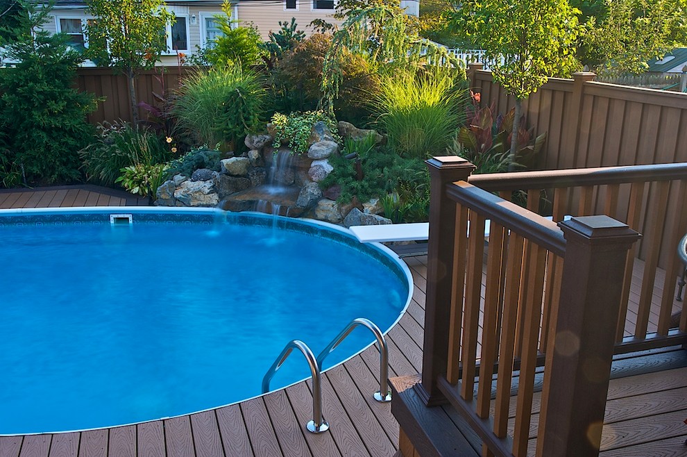Mid-sized elegant backyard pool photo in New York with decking