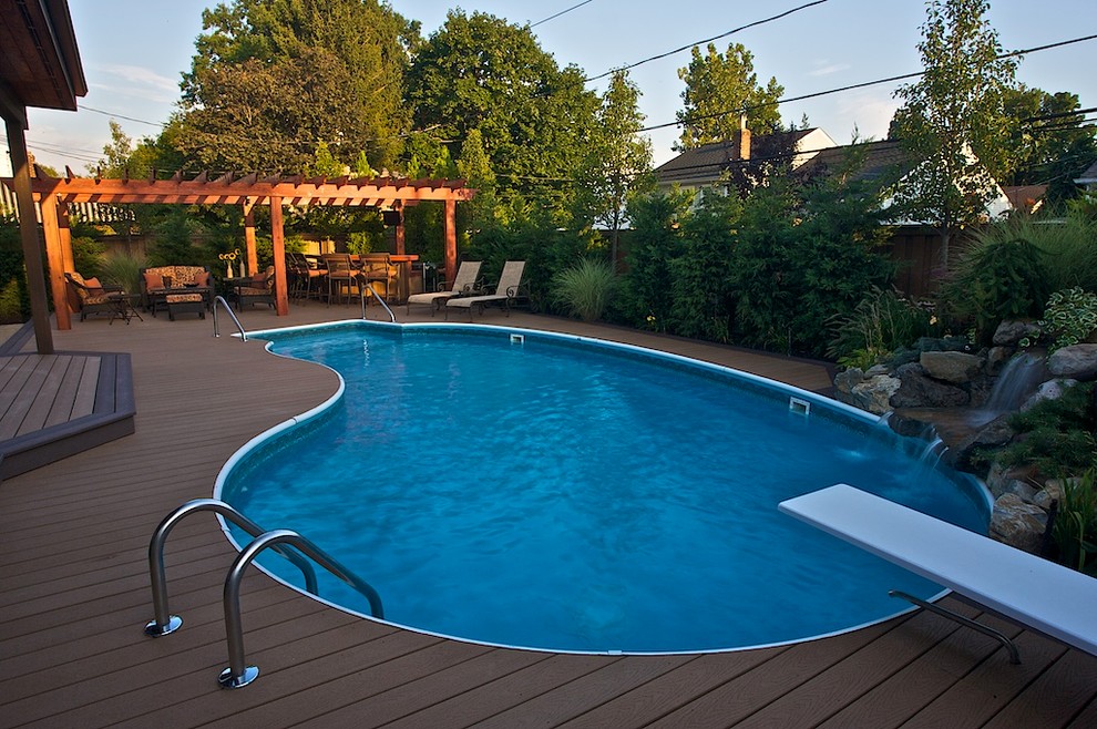 Foto de piscina tradicional de tamaño medio en patio trasero con entablado