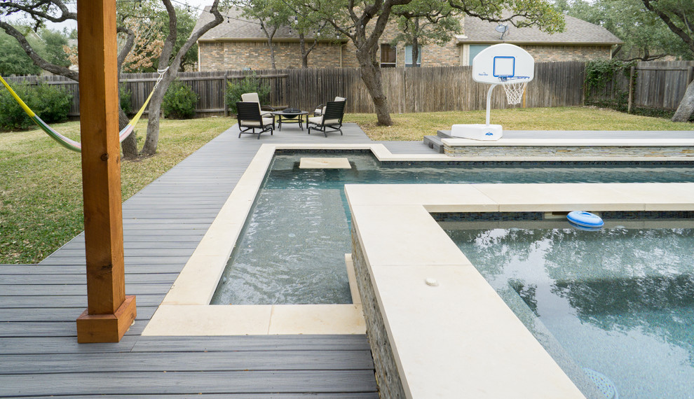 Esempio di una grande piscina design rettangolare dietro casa con una vasca idromassaggio e pedane