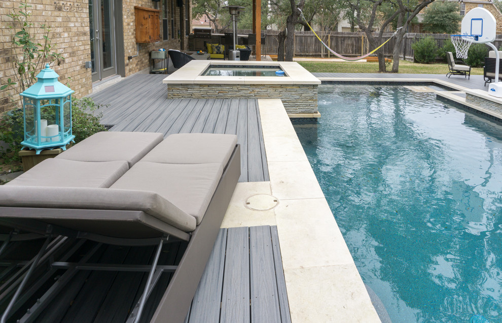 Idee per una grande piscina minimal rettangolare dietro casa con una vasca idromassaggio e pedane