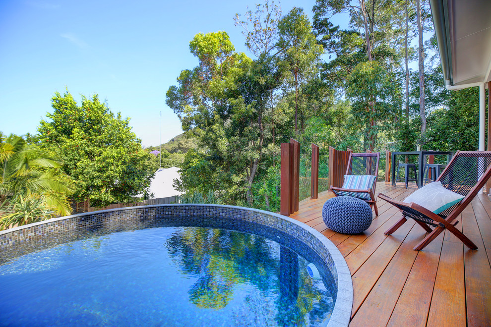Idées déco pour une petite piscine hors-sol et arrière contemporaine ronde avec une terrasse en bois.