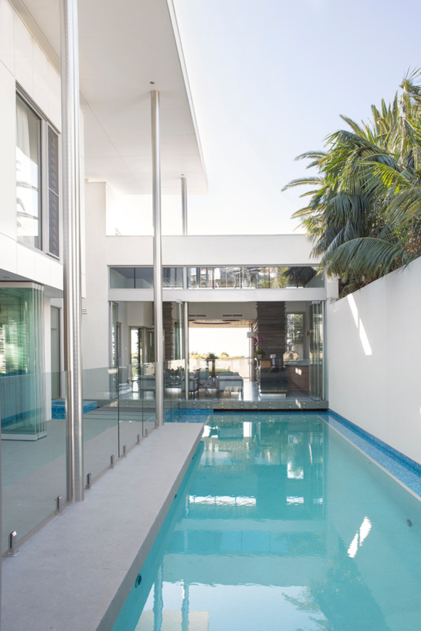 Idee per una piscina monocorsia minimal rettangolare con pavimentazioni in cemento