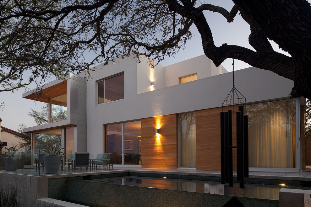 Großer Moderner Infinity-Pool hinter dem Haus in rechteckiger Form mit Betonboden in Austin