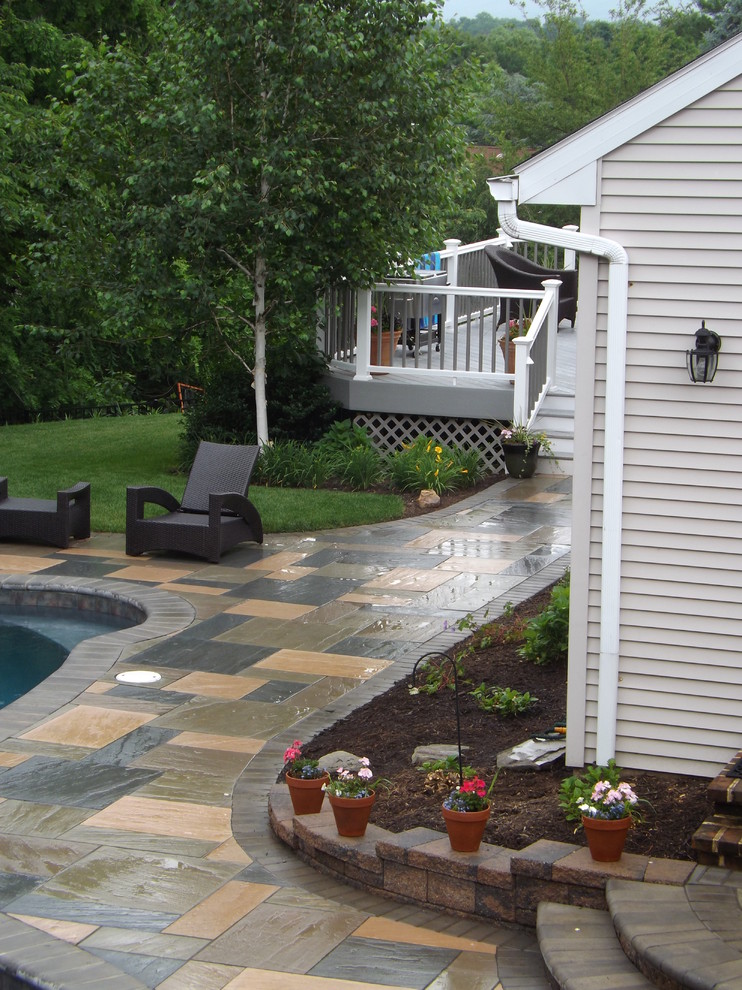 Imagen de piscinas y jacuzzis clásicos grandes tipo riñón en patio trasero con adoquines de hormigón