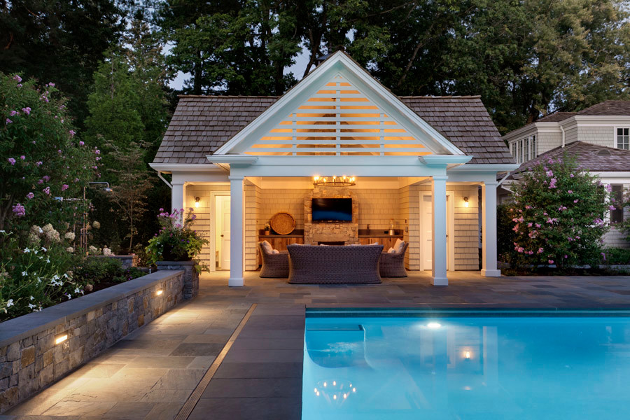Foto di una piscina monocorsia classica rettangolare dietro casa con una dépendance a bordo piscina e pavimentazioni in pietra naturale