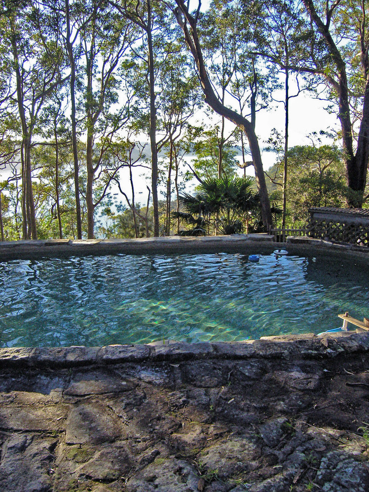 Inspiration pour une très grande piscine naturelle et arrière bohème sur mesure avec un point d'eau et des pavés en pierre naturelle.