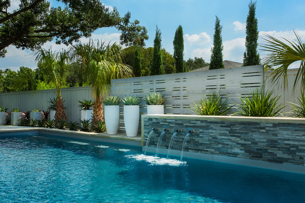 Foto de piscinas y jacuzzis alargados retro de tamaño medio rectangulares en patio trasero con adoquines de hormigón