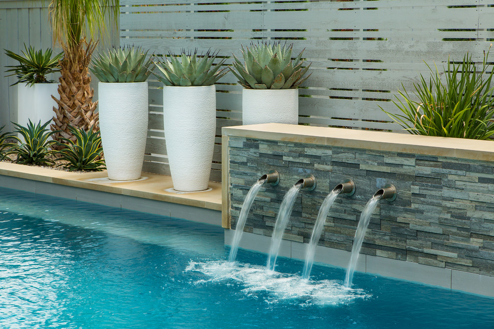 Ejemplo de piscinas y jacuzzis alargados vintage de tamaño medio rectangulares en patio trasero con adoquines de hormigón