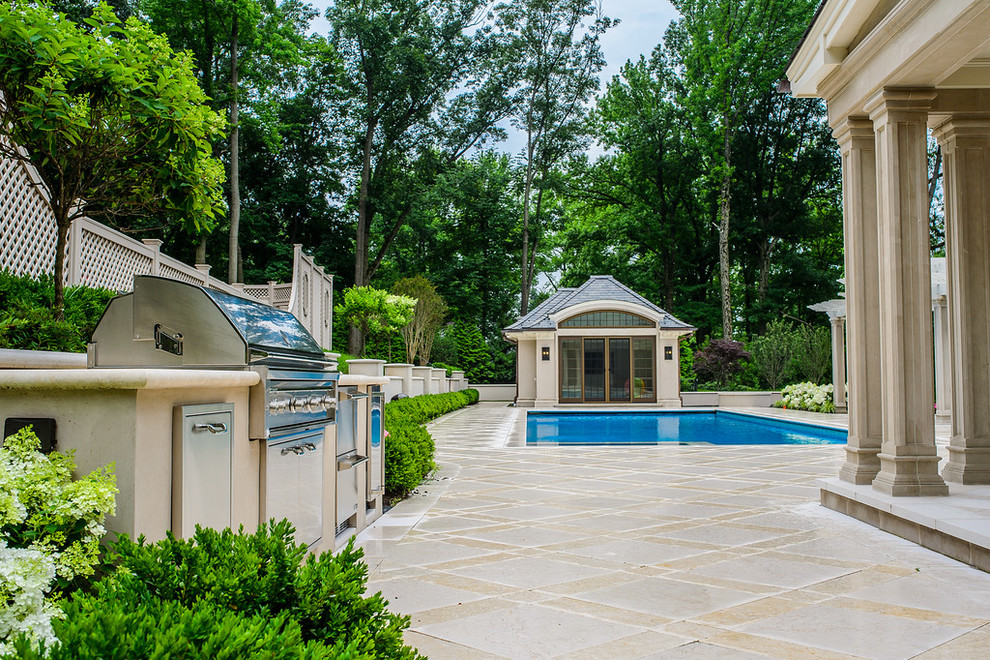 Modelo de casa de la piscina y piscina clásica grande rectangular en patio trasero con adoquines de hormigón