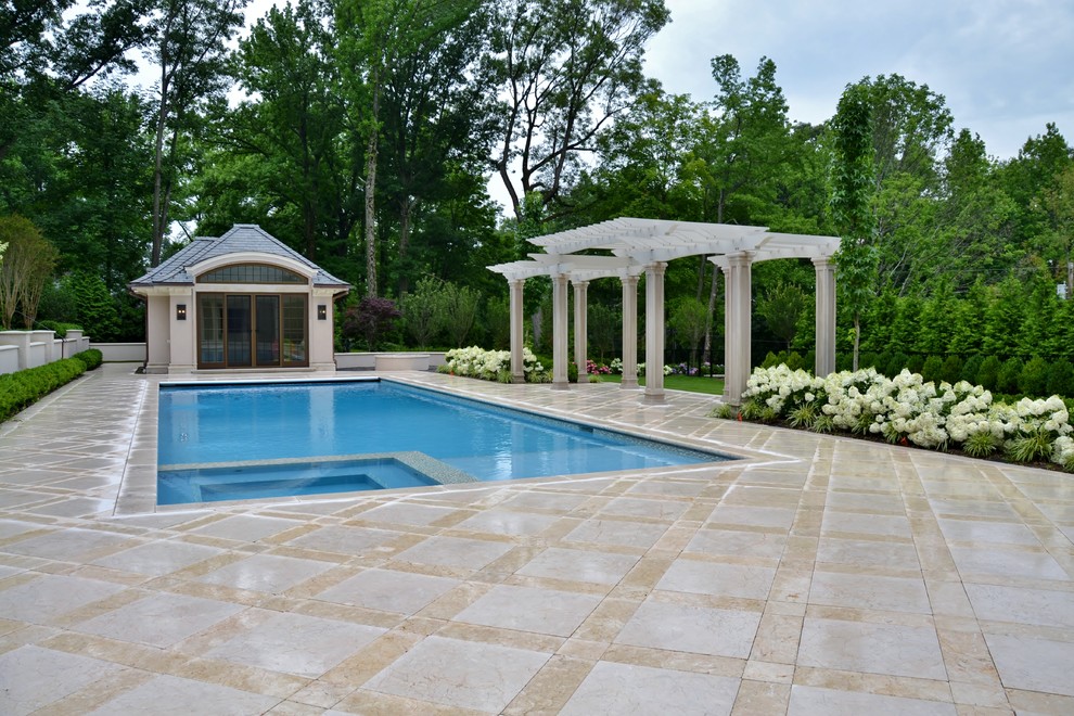 Foto de casa de la piscina y piscina clásica grande rectangular en patio trasero con adoquines de hormigón