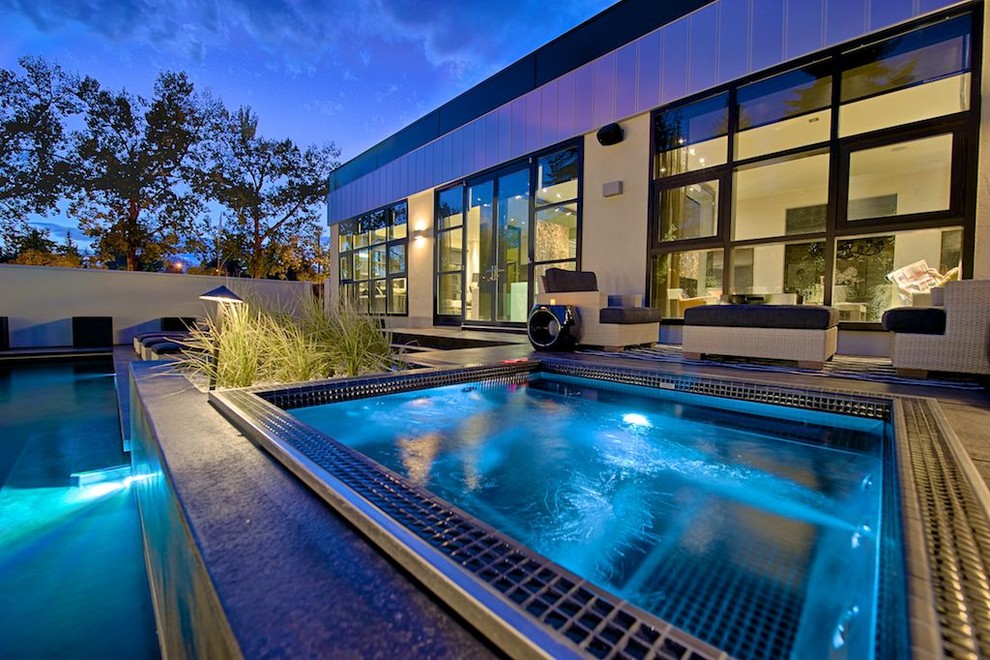 Пример оригинального дизайна: прямоугольный бассейн на заднем дворе в стиле модернизм с джакузи