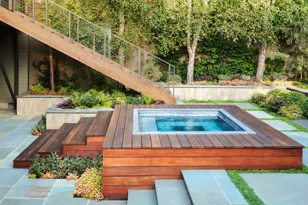 Foto de piscinas y jacuzzis elevados modernos pequeños rectangulares en patio con adoquines de hormigón