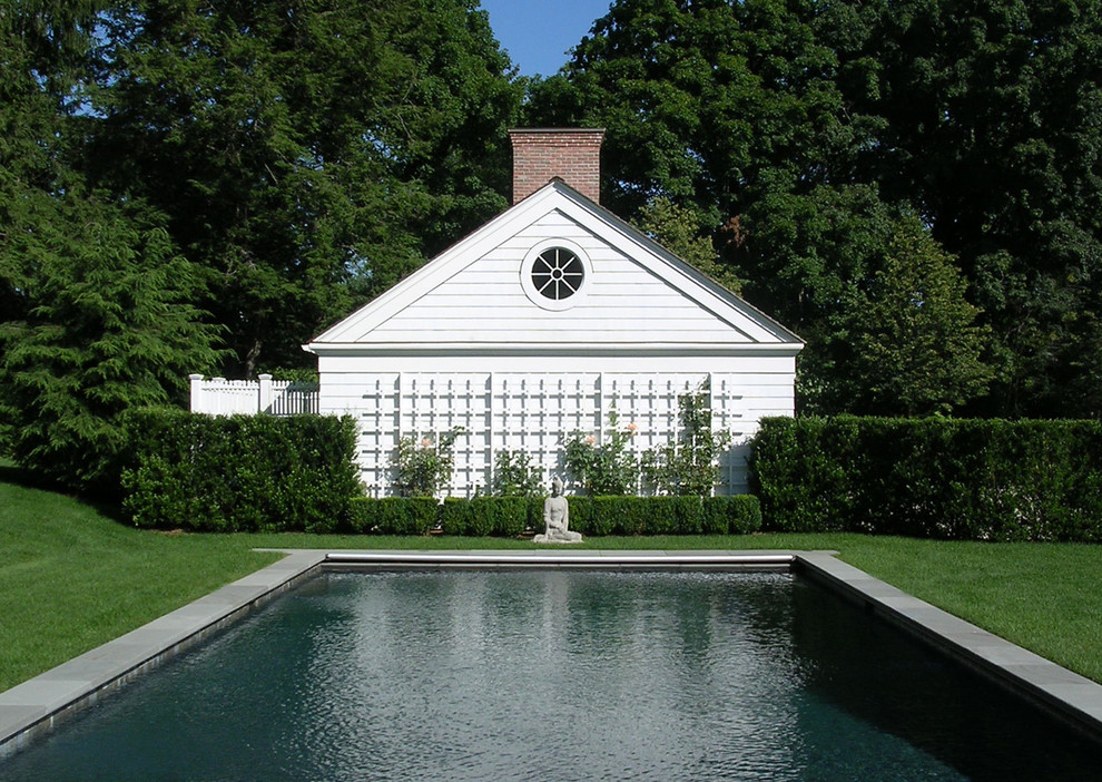Bild på en mellanstor vintage rektangulär träningspool på baksidan av huset, med poolhus och naturstensplattor