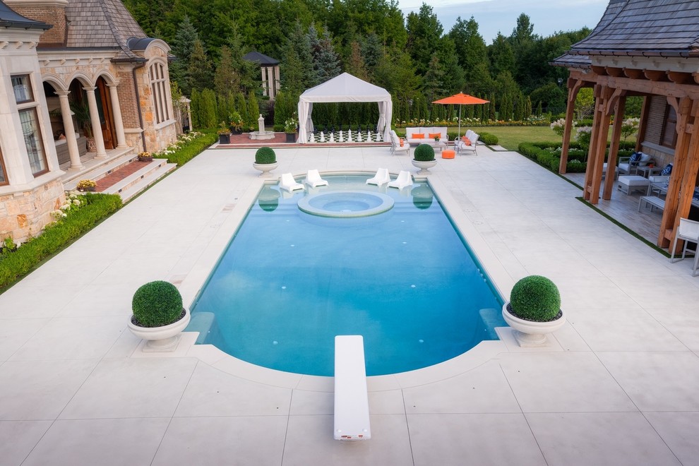 Foto de piscinas y jacuzzis contemporáneos extra grandes a medida en patio trasero con suelo de hormigón estampado