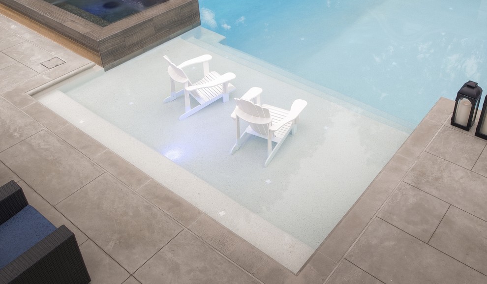 Idée de décoration pour un couloir de nage latéral design de taille moyenne et rectangle avec un bain bouillonnant et une dalle de béton.