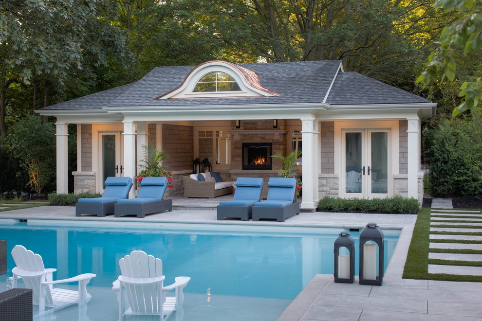 Imagen de casa de la piscina y piscina alargada actual de tamaño medio rectangular en patio lateral con losas de hormigón