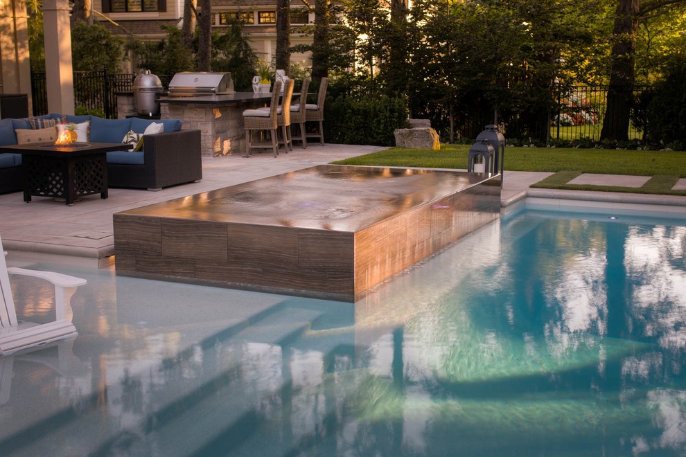 Esempio di una piscina monocorsia contemporanea rettangolare di medie dimensioni e nel cortile laterale con una vasca idromassaggio e lastre di cemento