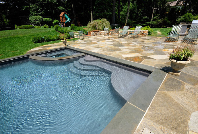 Imagen de piscina clásica rectangular con adoquines de piedra natural