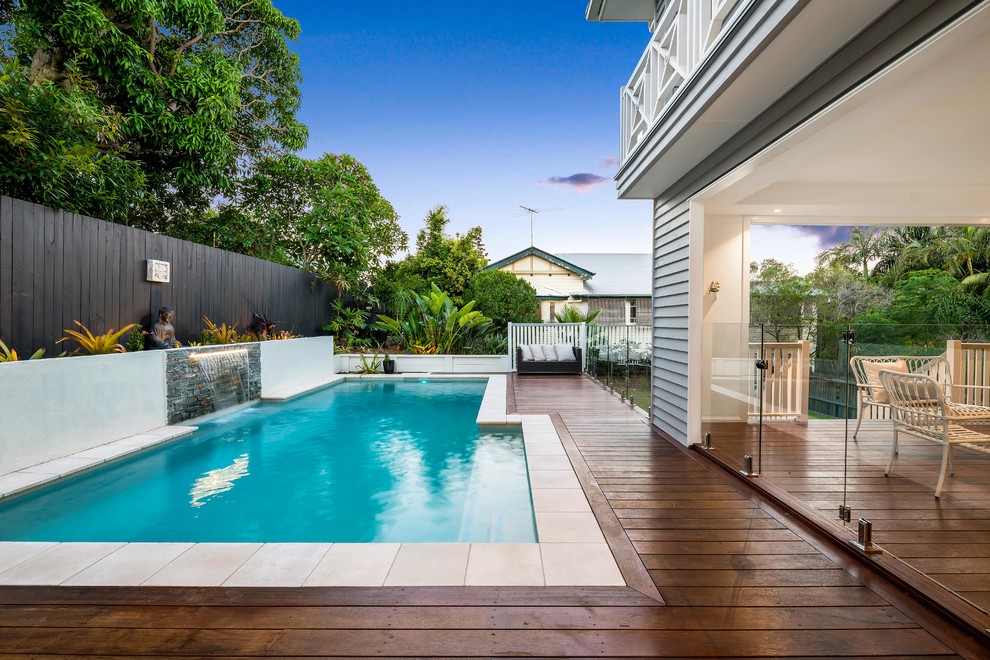 Klassischer Schwimmteich hinter dem Haus in rechteckiger Form mit Wasserspiel und Dielen in Brisbane
