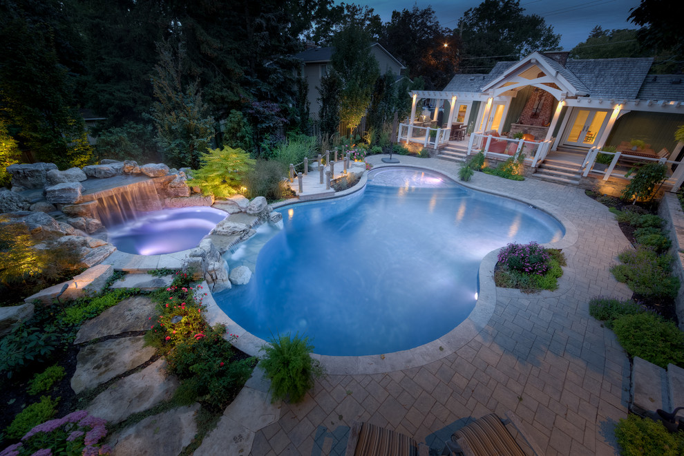 Hot tub - mid-sized contemporary backyard brick and custom-shaped natural hot tub idea in Toronto