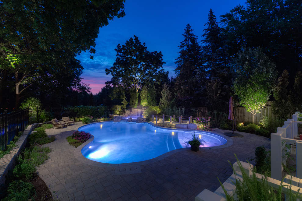 Ispirazione per una piscina naturale minimal personalizzata di medie dimensioni e dietro casa con una vasca idromassaggio e pavimentazioni in mattoni