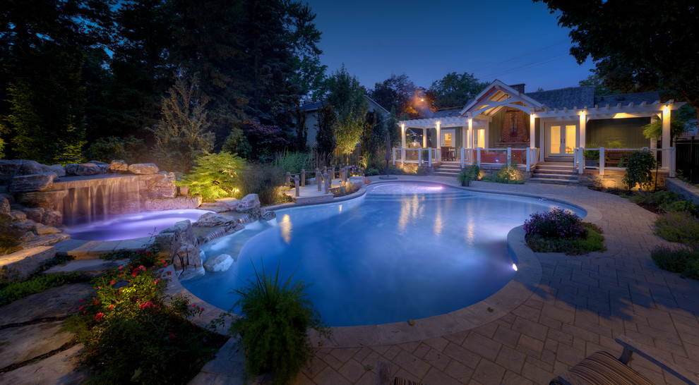 Пример оригинального дизайна: естественный бассейн среднего размера, произвольной формы на заднем дворе в современном стиле с джакузи и мощением клинкерной брусчаткой