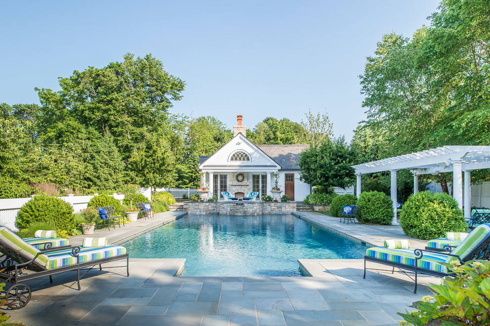 Traditional rectangular swimming pool in New York with a pool house.