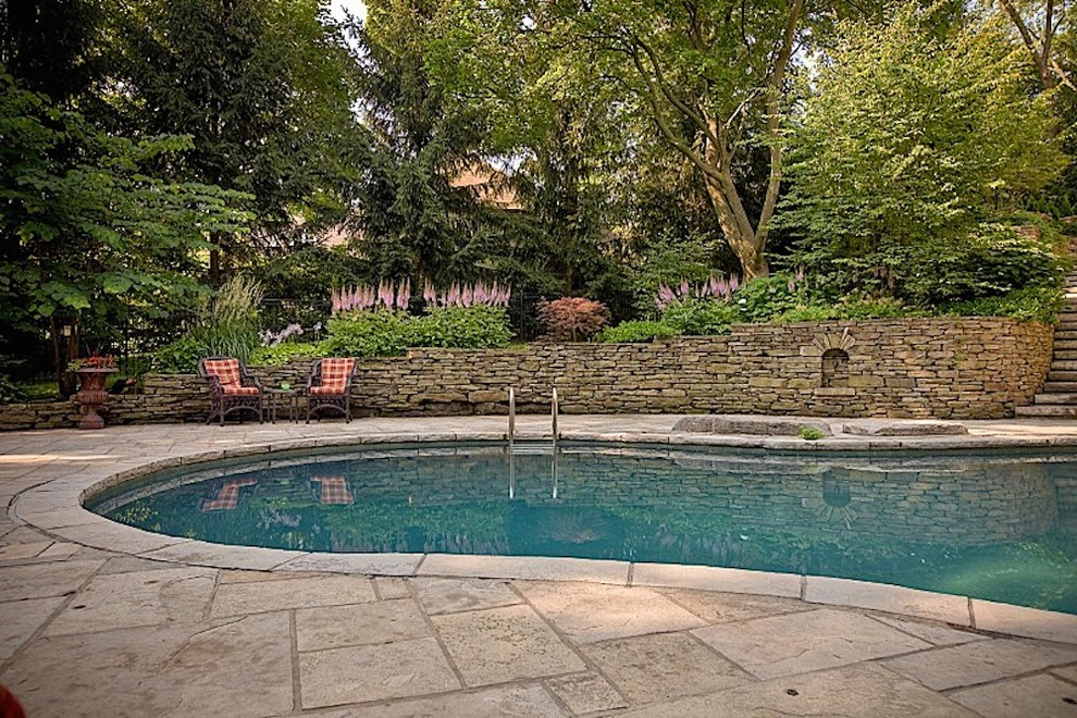 На фото: естественный бассейн среднего размера на заднем дворе в классическом стиле с покрытием из каменной брусчатки