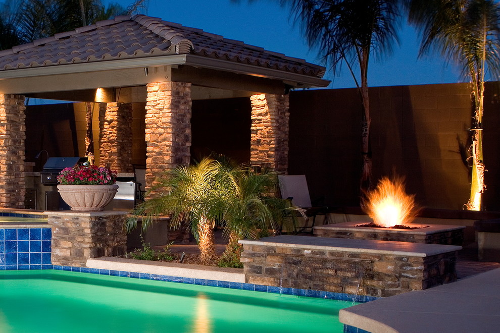 Modelo de casa de la piscina y piscina natural mediterránea grande a medida en patio trasero con adoquines de piedra natural
