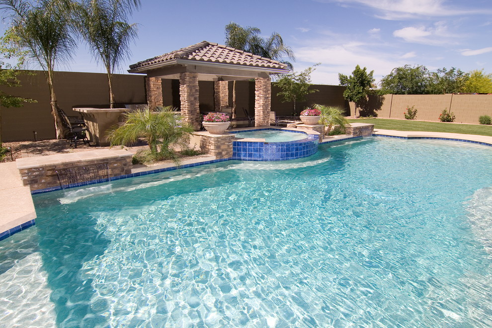 Diseño de casa de la piscina y piscina natural mediterránea grande a medida en patio trasero con adoquines de piedra natural
