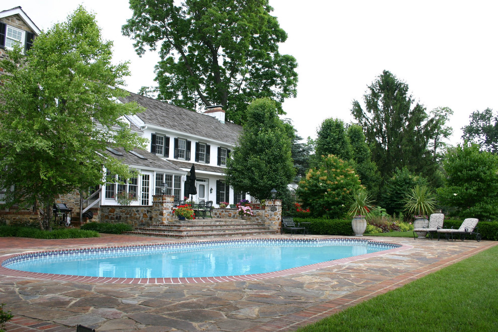 Klassischer Pool hinter dem Haus in runder Form mit Natursteinplatten in Philadelphia