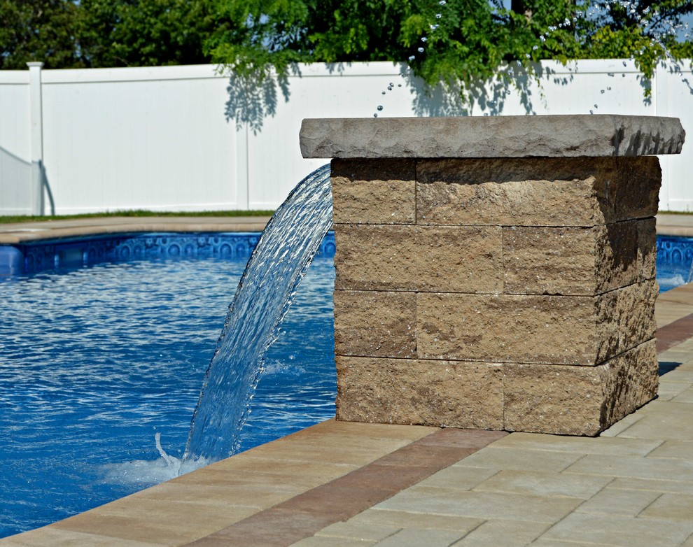 На фото: бассейн произвольной формы на заднем дворе в классическом стиле с фонтаном и мощением тротуарной плиткой