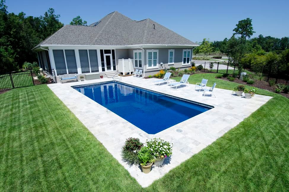 Идея дизайна: большой прямоугольный бассейн на заднем дворе в классическом стиле с покрытием из каменной брусчатки