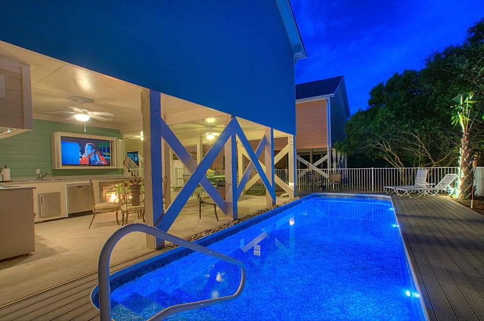 Ejemplo de casa de la piscina y piscina alargada tradicional de tamaño medio rectangular en patio trasero con entablado